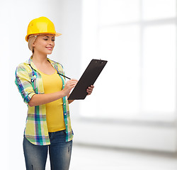 Image showing smiling woman in helmet with clipboard