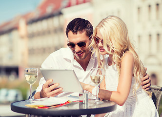 Image showing couple looking at tablet pc in cafe