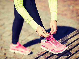 Image showing runner woman lacing trainers shoes