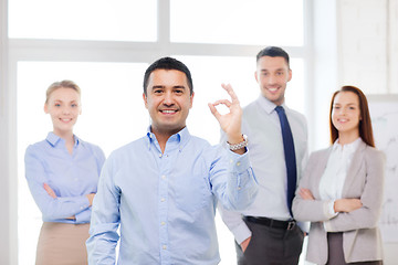 Image showing smiling businessman showing ok-sign in office