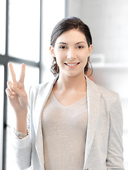 Image showing confident young woman showing v-sign