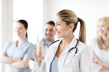 Image showing female doctor holding syringe with injection