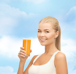 Image showing smiling woman holding glass of orange juice