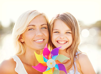 Image showing happy mother and child girl with pinwheel toy