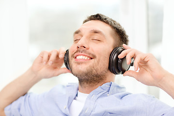 Image showing smiling young man in headphones at home