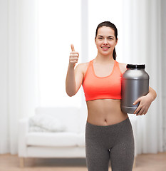 Image showing teenage girl with jar of protein showing thumbs up