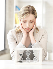 Image showing pensive businesswoman with sand glass