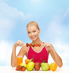 Image showing smiling young woman with organic food on the table