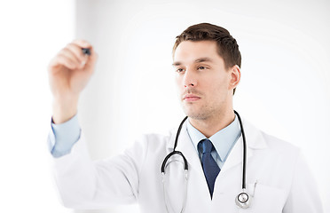 Image showing young doctor working with something imaginary