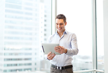 Image showing smiling businessman with tablet pc in office