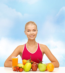 Image showing smiling woman with organic food or fruits on table