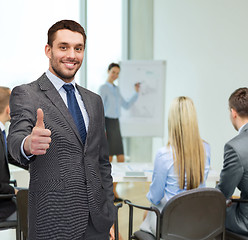 Image showing handsome buisnessman showing thumbs up in office
