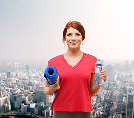 Image showing smiling girl with bottle of water after exercising