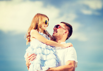 Image showing happy father and child in sunglasses over blue sky