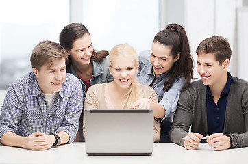 Image showing smiling students looking at laptop at school