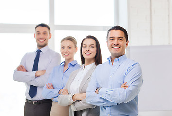 Image showing smiling businessman in office with team on back