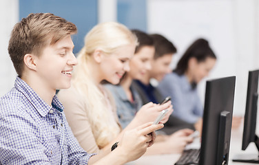 Image showing students with computer monitor and smartphones