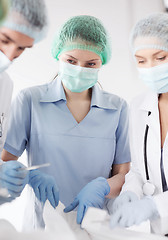 Image showing young group of doctors doing operation