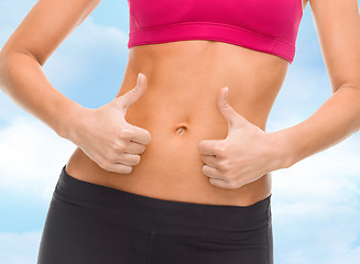 Image showing close up of female abs and hands showing thumbs up