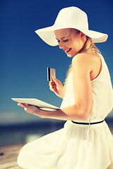 Image showing woman in hat doing online shopping outdoors