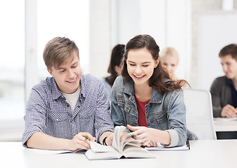 Image showing two teenagers with notebooks and book at school