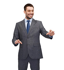 Image showing businessman working with imaginary virtual screen