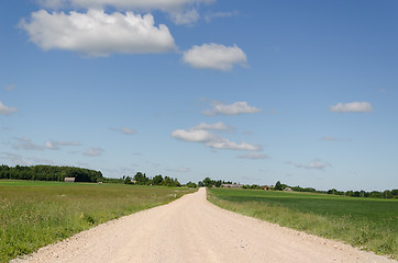 Image showing gravel road continues along  fields and blue sky  