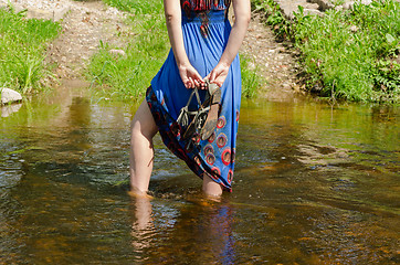 Image showing girl legs with dress standing in flowing stream