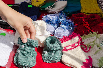 Image showing Hand take wool knitted warm cozy baby shoes 