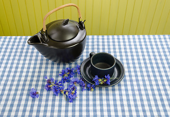 Image showing clay tea set with fresh picked cornflower on table 