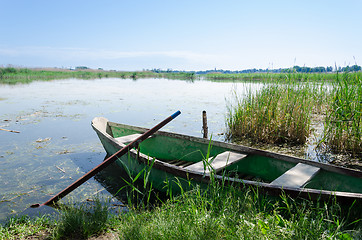 Image showing old boat scratched paint with oars coast on spring 