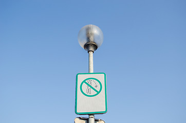 Image showing warning sign on littering streets on street lamp 