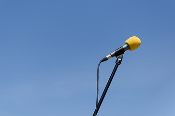 Image showing yellow microphone on blue sky background 