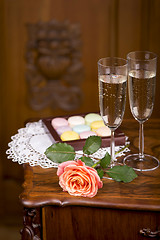 Image showing Two glasses of sparkling wine or champagne with small colorful macaroons