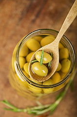 Image showing Close up green olives in bank,  rosemary