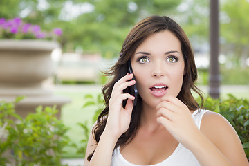 Image showing Stunned Young Adult Female Talking on Cell Phone Outdoors