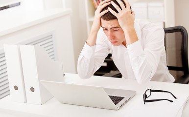 Image showing Despairing businessman sitting at desk