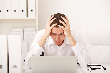 Image showing Despairing businessman sitting at desk