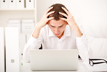 Image showing Despairing businessman sitting at desk