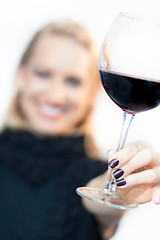 Image showing Toasting with a glass of red wine.