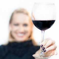 Image showing Toasting with a glass of red wine.