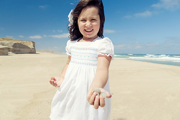 Image showing Girl on the beach holding stones