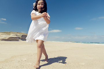 Image showing Girl on the beach holding stones