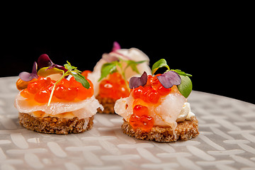 Image showing Salmon eggs, fish, and herbs canapes