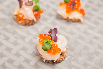 Image showing Salmon eggs, fish, and herbs canapes