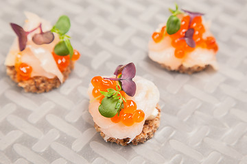 Image showing Salmon eggs, fish, and herbs canapes