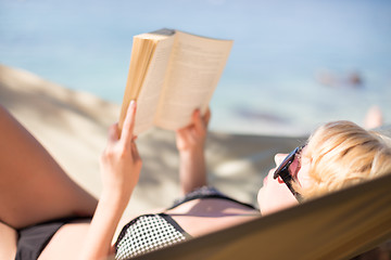 Image showing Lady reading a book in a hammock.