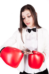 Image showing young businesswoman in boxing gloves with cash