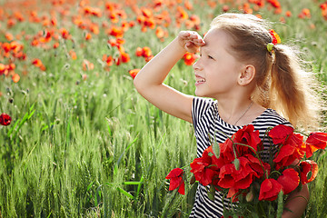 Image showing Little happy girl on the poppy meadow