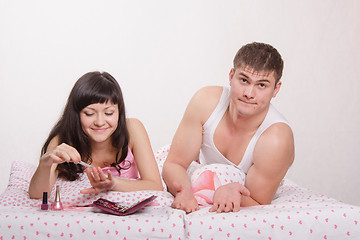 Image showing Woman tired of waiting for guy that deals with manicure